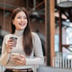 Pretty asian woman holding coffee looking away from smartphone while standing or walking in the cafe Pretty asian woman holding coffee looking away from smartphone while standing or walking in the cafe - PhotoDune Item for Sale