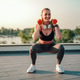 Woman exercising with dumbbells doing squats outdoors Woman exercising with dumbbells doing squats outdoors - PhotoDune Item for Sale