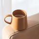 Close Up Ceramic Coffee Mug on Sofa Armrest with Textured Pillows. Cozy Home Interior Close Up Ceramic Coffee Mug on Sofa Armrest with Textured Pillows. Cozy Home Interior - PhotoDune Item for Sale