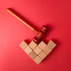 The image features a wooden gavel resting on a structure of small wooden building blocks The image features a wooden gavel resting on a structure of small wooden building blocks - PhotoDune Item for Sale