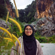 Hijab teenager wearing glasses standing behind the tall grass in nature. Hijab teenager wearing glasses standing behind the tall grass in nature. - PhotoDune Item for Sale