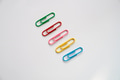 Colored paper clips close-up on a white background Colored paper clips close-up on a white background - PhotoDune Item for Sale