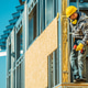 Worker Installs Building Materials at a Construction Site Worker Installs Building Materials at a Construction Site - PhotoDune Item for Sale