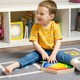 Toddler boy with a bandage or cast on his leg plays with wooden blocks. Toddler boy with a bandage or cast on his leg plays with wooden blocks. - PhotoDune Item for Sale