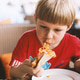 Cute child boy bringing pizza slice up to his mouth to eat . Kids loves eat bad food Kids being kids Cute child boy bringing pizza slice up to his mouth to eat . Kids loves eat bad food Kids being kids - PhotoDune Item for Sale