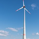 Wind turbine close-up in a field of flowering rapeseed against a blue sky, renewable energy. Wind turbine close-up in a field of flowering rapeseed against a blue sky, renewable energy. - PhotoDune Item for Sale
