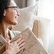 White woman smiling while sitting with gift box on floor at home White woman smiling while sitting with gift box on floor at home - PhotoDune Item for Sale