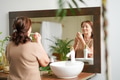 Portrait of senior woman taking care of her skin, looking at mirror Portrait of senior woman taking care of her skin, looking at mirror - PhotoDune Item for Sale