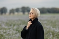 Stylish woman in black coat and glasses on meadow with flowers Stylish woman in black coat and glasses on meadow with flowers - PhotoDune Item for Sale