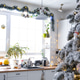 Christmas decor in white kitchen, mess dishes, contemporary interior with a snowy Christmas tree Christmas decor in white kitchen, mess dishes, contemporary interior with a snowy Christmas tree - PhotoDune Item for Sale