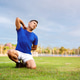 Asian man in blue t shirt is kneeling on grass and touching or massaging his back.Pain or injury. Asian man in blue t shirt is kneeling on grass and touching or massaging his back.Pain or injury. - PhotoDune Item for Sale