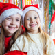 Smiling girls wearing Santa hats at a festive holiday party indoors Smiling girls wearing Santa hats at a festive holiday party indoors - PhotoDune Item for Sale