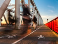 Ghosts cycling on cycle path crossing bridge long exposure blurred people on bike. Low sunlight glow Ghosts cycling on cycle path crossing bridge long exposure blurred people on bike. Low sunlight glow - PhotoDune Item for Sale