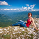 Young woman sitting on a rocky mountain peak enjoying the landscape. Young woman sitting on a rocky mountain peak enjoying the landscape. - PhotoDune Item for Sale