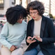 Two friends looking at smartphone in the street Two friends looking at smartphone in the street - PhotoDune Item for Sale