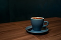 Coffee in blue cup on wooden table in cafe with dark background Coffee in blue cup on wooden table in cafe with dark background - PhotoDune Item for Sale