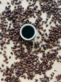 Cup of coffee overhead with coffee beans around it on a textured surface. Cup of coffee overhead with coffee beans around it on a textured surface. - PhotoDune Item for Sale