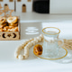 On the white table there is water in a glass, a date, a rosary, and a blurred tray with nuts. On the white table there is water in a glass, a date, a rosary, and a blurred tray with nuts. - PhotoDune Item for Sale