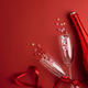 Champagne Bottle and Flute Glasses with Colorful Hearts on Red Background. Champagne Bottle and Flute Glasses with Colorful Hearts on Red Background. - PhotoDune Item for Sale