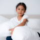 Happy girl hugging pillows on bed in bedroom Happy girl hugging pillows on bed in bedroom - PhotoDune Item for Sale