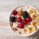 Oatmeal with fresh berries, nuts, and banana fruit. Healthy food concept. Top view. Oatmeal with fresh berries, nuts, and banana fruit. Healthy food concept. Top view. - PhotoDune Item for Sale