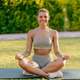 A smiling woman is practicing yoga amidst the beautiful nature during a serene sunset A smiling woman is practicing yoga amidst the beautiful nature during a serene sunset - PhotoDune Item for Sale