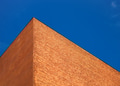 A wall of brick against a blue sky. Abstract shapes of buildings in the city. A wall of brick against a blue sky. Abstract shapes of buildings in the city. - PhotoDune Item for Sale