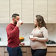 Pregnant couple talking, drinking coffee in kitchen Pregnant couple talking, drinking coffee in kitchen - PhotoDune Item for Sale