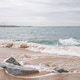 Tranquil overcast day at a coastal beach with gentle waves and rock formations Tranquil overcast day at a coastal beach with gentle waves and rock formations - PhotoDune Item for Sale