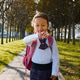 Child girl in school uniform is walking quickly in the park and talking on her pink wrist smart Child girl in school uniform is walking quickly in the park and talking on her pink wrist smart - PhotoDune Item for Sale