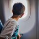 Young boy flying in a plane looking out the window Young boy flying in a plane looking out the window - PhotoDune Item for Sale