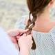 Adult woman with brown hair getting ribbon braid outdoors in natural light Adult woman with brown hair getting ribbon braid outdoors in natural light - PhotoDune Item for Sale