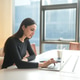 Young professional woman working on a laptop in a modern office with city views Young professional woman working on a laptop in a modern office with city views - PhotoDune Item for Sale
