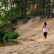 Rear view of little girl with long hair run on sandy beach near river in forest Rear view of little girl with long hair run on sandy beach near river in forest - PhotoDune Item for Sale