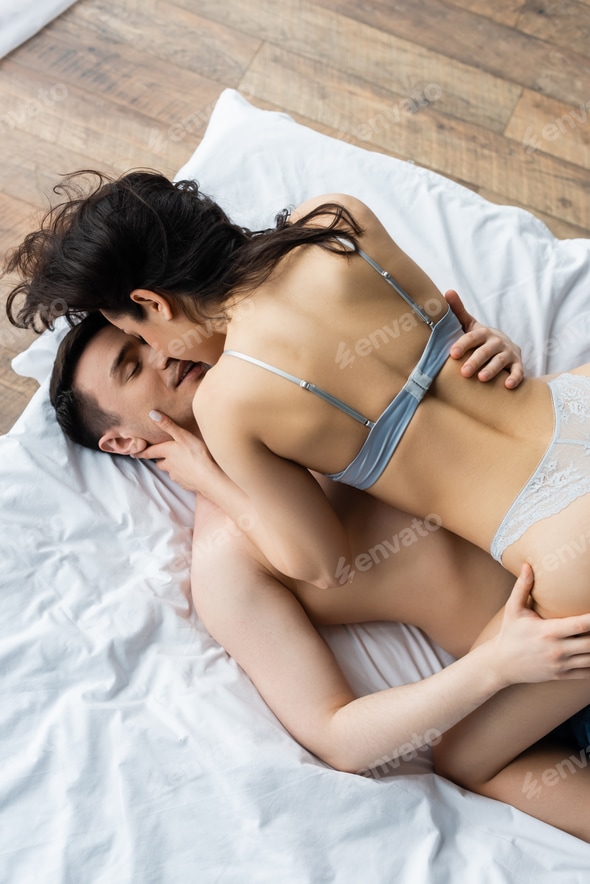 top view of sexy woman in underwear kissing man on bed Stock Photo by LightFieldStudios top view of sexy woman in underwear kissing man on bed Stock Photo by LightFieldStudios