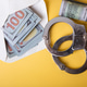 Handcuffs, dollar bills, and envelope symbolizing corruption and crime Handcuffs, dollar bills, and envelope symbolizing corruption and crime - PhotoDune Item for Sale