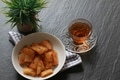 Fried Cassava served with hot tea on dark slate background Fried Cassava served with hot tea on dark slate background - PhotoDune Item for Sale