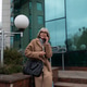 Elderly woman in a stylish coat sitting outside a modern building while talking on her phone in a Elderly woman in a stylish coat sitting outside a modern building while talking on her phone in a - PhotoDune Item for Sale