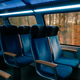 Empty modern train seats with a blue interior, illuminated by soft overhead lighting Empty modern train seats with a blue interior, illuminated by soft overhead lighting - PhotoDune Item for Sale