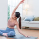 Serene woman stretching joyfully in bright, modern living room yoga session Serene woman stretching joyfully in bright, modern living room yoga session - PhotoDune Item for Sale