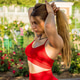Energetic girl in red sportswear making a ponytail Energetic girl in red sportswear making a ponytail - PhotoDune Item for Sale