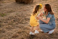 Happy girl child in yellow dress hugs young mom in autumn field Happy girl child in yellow dress hugs young mom in autumn field - PhotoDune Item for Sale