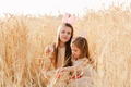 Two little girls sisters sitting in wheat field collecting red eggs in basket. Celebrating Easter Two little girls sisters sitting in wheat field collecting red eggs in basket. Celebrating Easter - PhotoDune Item for Sale