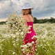 A beautiful young girl in a dress holds a bouquet of daisies in a meadow in summer A beautiful young girl in a dress holds a bouquet of daisies in a meadow in summer - PhotoDune Item for Sale