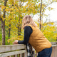Woman standing on bridge looking at autumn colors Woman standing on bridge looking at autumn colors - PhotoDune Item for Sale