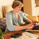 Senior woman with short gray hair working on laptop at home Senior woman with short gray hair working on laptop at home - PhotoDune Item for Sale