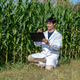 Happy asian agricultural researcher writing on clipboard aside green crop sitting crouching in farm. Happy asian agricultural researcher writing on clipboard aside green crop sitting crouching in farm. - PhotoDune Item for Sale
