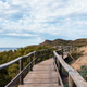 Wooden walkway leading to the beach in Menorca under a cloudy sky. Wooden walkway leading to the beach in Menorca under a cloudy sky. - PhotoDune Item for Sale