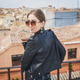 Stylish woman posing in the old part of the town against tile roofs. Medieval city of Toledo in the Stylish woman posing in the old part of the town against tile roofs. Medieval city of Toledo in the - PhotoDune Item for Sale
