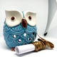 Ceramic Blue Owl Figurine with Scroll and Gold Ribbon on White Background Ceramic Blue Owl Figurine with Scroll and Gold Ribbon on White Background - PhotoDune Item for Sale